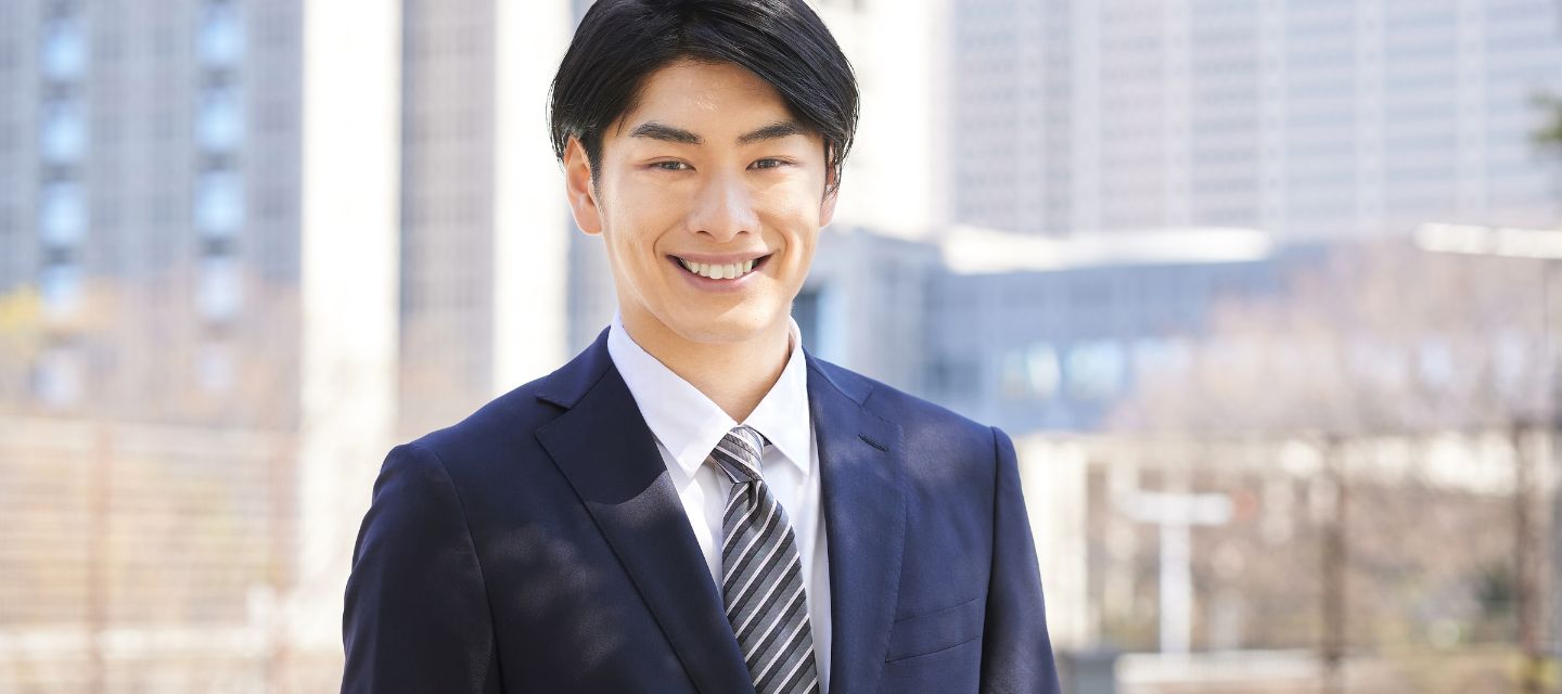 パソコンの前で考えるスーツ姿の男性